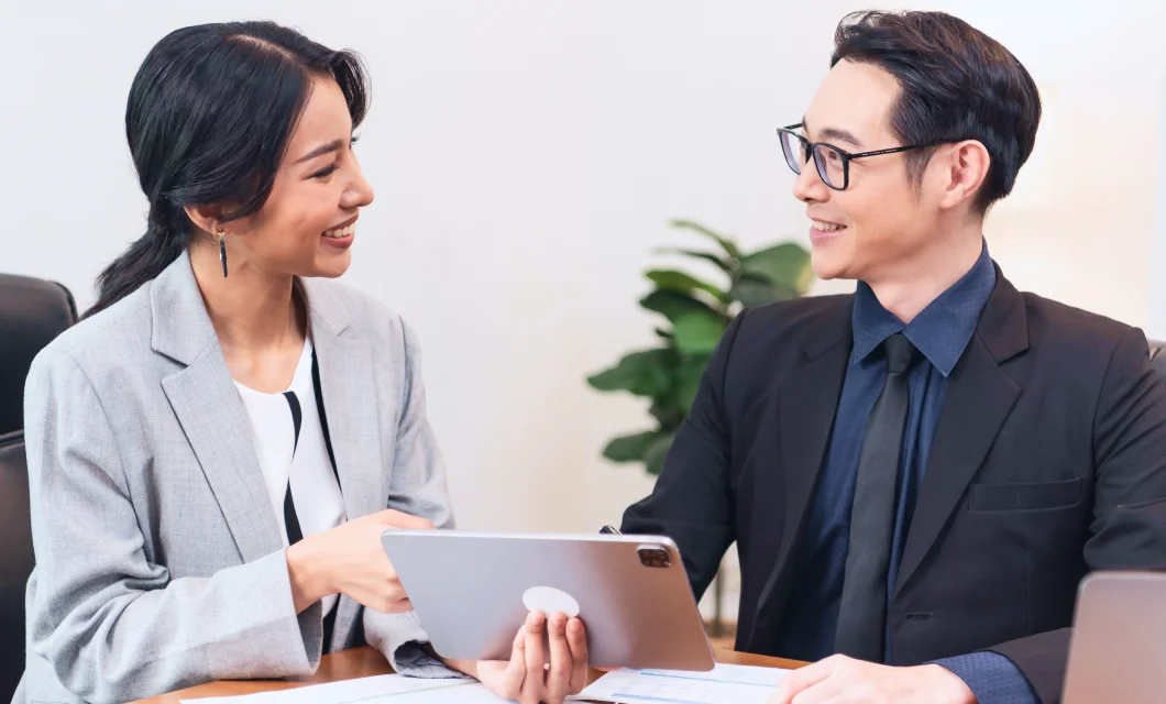 Smiling Asian Businesswoman Showing Tablet Her Manager Meeting Office 1